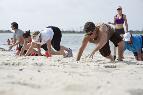 Participants of a beach boot camp class crawl across Soundside Beach at Hurlburt Field, Fla., May 18, 2013. The class combined a number of physical challenges and obstacles designed to push people past their physical limits.